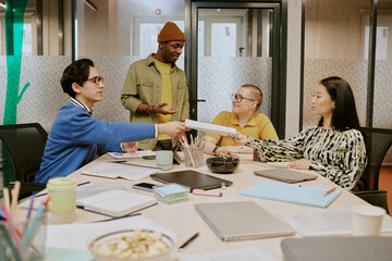 Group of young ethnically diverse people wearing casual clothes working together on project during...