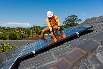 Solar panel technician with drill installing solar panels