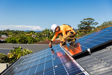 Solar panel technician with drill installing solar panels