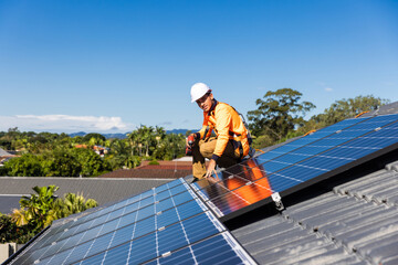 Solar panel technician with drill installing solar panels