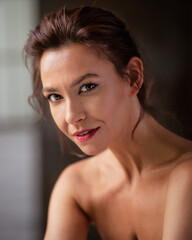 Naklejka premium Close-up portrait of an attractive woman with brunette hair looking at camera