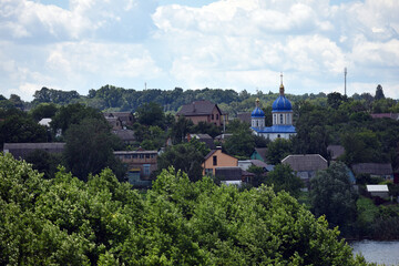 church. view of the Ukrainian church in the village. religion, Christianity. church holidays. crosses on the domes. no people. roofs of houses. summer or spring time. Orthodox temple.