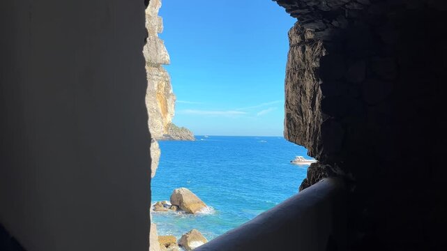 Breathtaking view from a rock window of vibrant blue Amalfi coast, Italy