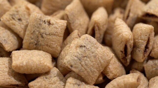 Corn snack. Cereal pads with filling falling into bowl against white background