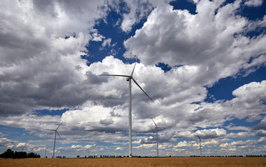 Elektrownia wiatrowa - wiatrak na tle błękitnego nieba z chmurami © arteffect.pl