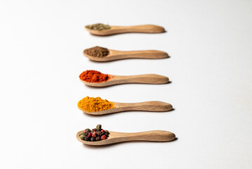 Multiple spices on the wooden spoons, chili, spice mix, turmeric, cumin, Italian herbs