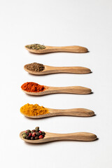 Multiple spices on the wooden spoons, chili, spice mix, turmeric, cumin, Italian herbs
