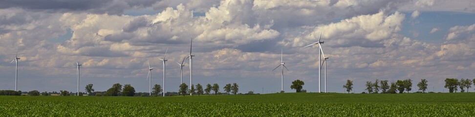 Elektrownia wiatrowa - wiatraki na tle błękitnego nieba z chmurami