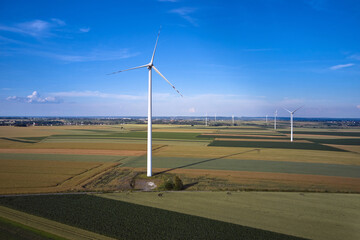 Elektrownia wiatrowa - wiatraki na tle błękitnego nieba z chmurami © arteffect.pl