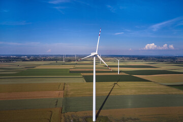 Elektrownia wiatrowa - wiatraki na tle błękitnego nieba z chmurami © arteffect.pl