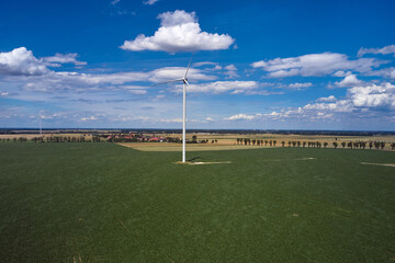 Elektrownia wiatrowa - wiatraki na tle błękitnego nieba z chmurami