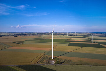 Elektrownia wiatrowa - wiatraki na tle błękitnego nieba z chmurami © arteffect.pl