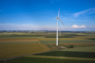 Elektrownia wiatrowa - wiatraki na tle błękitnego nieba z chmurami © arteffect.pl