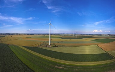 Elektrownia wiatrowa - wiatraki na tle błękitnego nieba z chmurami © arteffect.pl