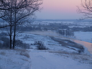The photo shows a winter landscape - mountains, meadow.