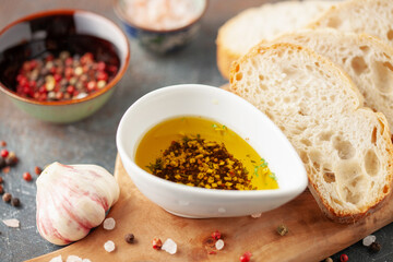 Bread dipping oil. Crusty bread ciabatta and bowl of olive oil with spices.