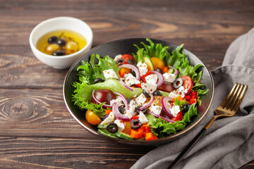 Greek salad of fresh cucumber, tomato, sweet pepper, red onion, feta cheese and olives with olive oil. Healthy food.
