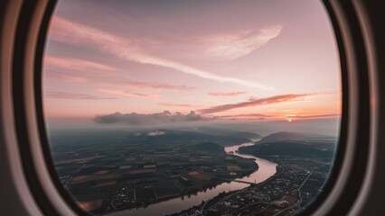 aerial view captured through the window of an airplane The landscape below reveals a patchwork quilt of farmland, winding rivers, and quaint towns. As the sun sets in the distance