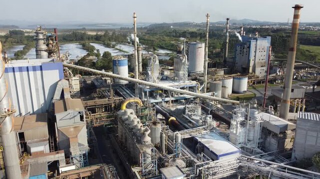 Vis&atilde;o a&eacute;rea de chamin&eacute;s e equipamentos soltando vapores e poluentes em uma ind&uacute;stria de papel e celulose em suzano, s&atilde;o paulo, brasil video drone 4k