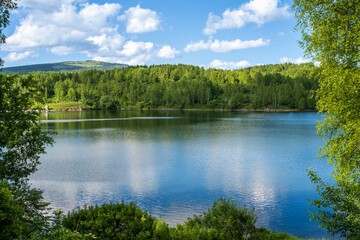 Vlasina lake scenery with beautiful clouds in the blue sky. Beautiful semi-artificial lake in Southeast Serbia.  The beautiful blue color of the water.