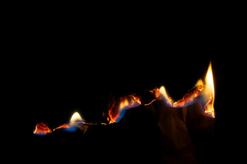 burning paper, glowing edge of paper on a black background.