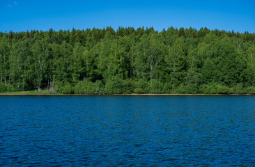 Vlasina lake scenery with beautiful clouds in the blue sky. Beautiful semi-artificial lake in Southeast Serbia.  The beautiful blue color of the water.