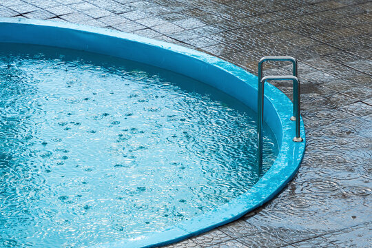 Rainy weather, raindrops fall into the swimming pool
