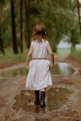 dziewczynka w białej sukience w kaloszach  © katarzyna