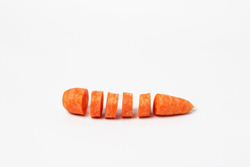 Whole carrots sliced ​​pieces, all in bright orange color prepared for cooking or for use in dishes such as salads or stir-fries isolated on white background