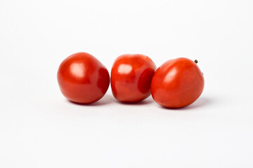 A small red tomato. Group of tomatoes isolated on white background.