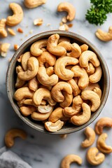 Naklejka premium A bowl of nuts with a green herb on the table. The nuts are in the shape of a half circle
