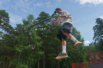 boy performs extreme stunts jumping with a scooter, extreme sports, jumping in the air