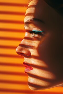 Profile of a woman with shadows from window blinds on her face