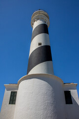 Low angle shot of the Favaritx lighthouse. Located on a rocky cliff next to the Mediterranean Sea....