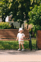 A happy boy in panama plays in a summer park in the shade of trees. Time in the fresh air.