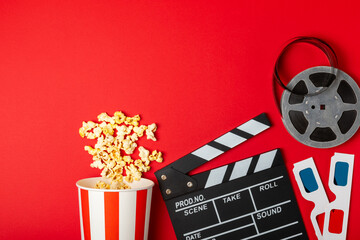 Tasty popcorn in buckets and cold cola drinks with cinema tickets, movie clapper and 3D eyeglasses...