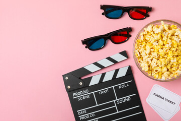 Tasty popcorn in buckets and cold cola drinks with cinema tickets, movie clapper and 3D eyeglasses...
