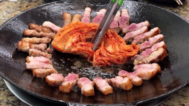 한국 전통 솥뚜껑 삼겹살 구이와 김치, 쌈채소