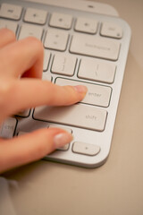close-up female young hands pressing the enter button on the keyboard office device nude manicure professional keyboard