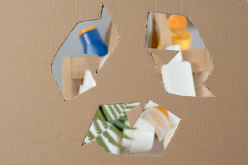 Recycling sign on cardboard paper on cosmetics background. Used cosmetic packaging. Plastic waste. Responsible consumption. Protect nature and save planet