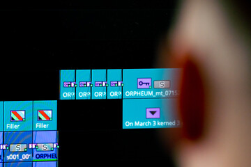 Close-up of man's head behind the monitor screen editing software is included, editing story dashboard, professional software for cinema and advertising