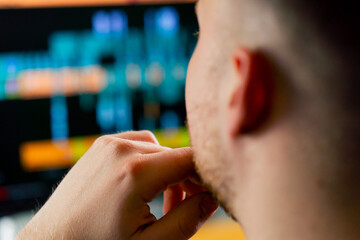 Close-up of man's head behind the monitor screen editing software is included, editing story dashboard, professional software for cinema and advertising