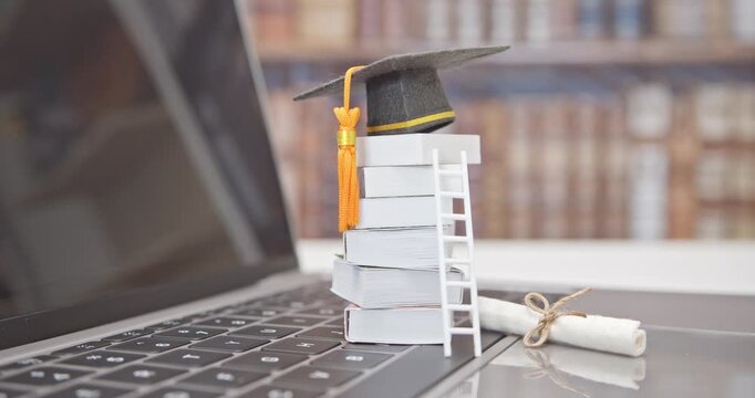 Graduate study abroad program to broaden learner's world view, e-learning concept : Graduation cap, foreign books on a laptop, depicts student attempting to study from a distance or learning from home
