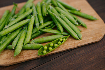 Fresh green peas on wooden background