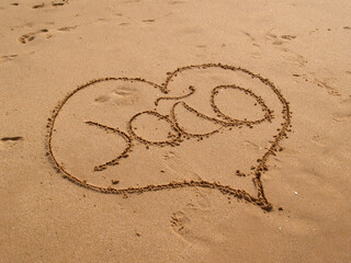 Heart drawn in beach sand with the name João inside, capturing a romantic and personal touch.