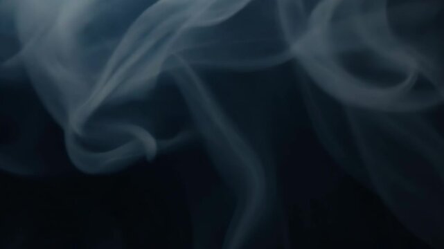 Gray smoke swirls at black background. Abstract dark atmospheric footage effect for halloween clip or tabaco advertising.