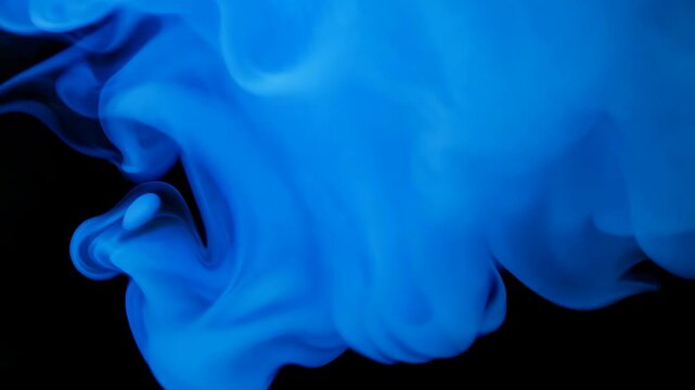 Blue smoke swirls at black background. Abstract dark atmospheric footage effect in cold lighting for halloween clip or tabaco advertising.
