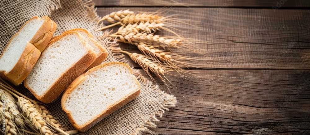 Aufkleber Copy space image of white bread slices and wheat ears displayed on burlap over a rustic wooden surface