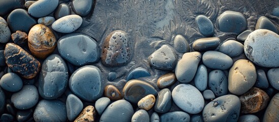 Unusually shaped sea stones on the beach creating a textured background for a copy space image