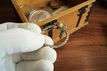 Old silver jewelry in the hand of an appraiser